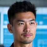 Headshot of Liam Chen, looking thoughtful, with a subtle blueprint overlay suggesting design.